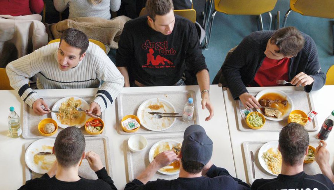 Сидит в столовой. Студенты едят в столовой. Столовая с людьми. Еда в студенческой столовой. Обед в столовой люди.