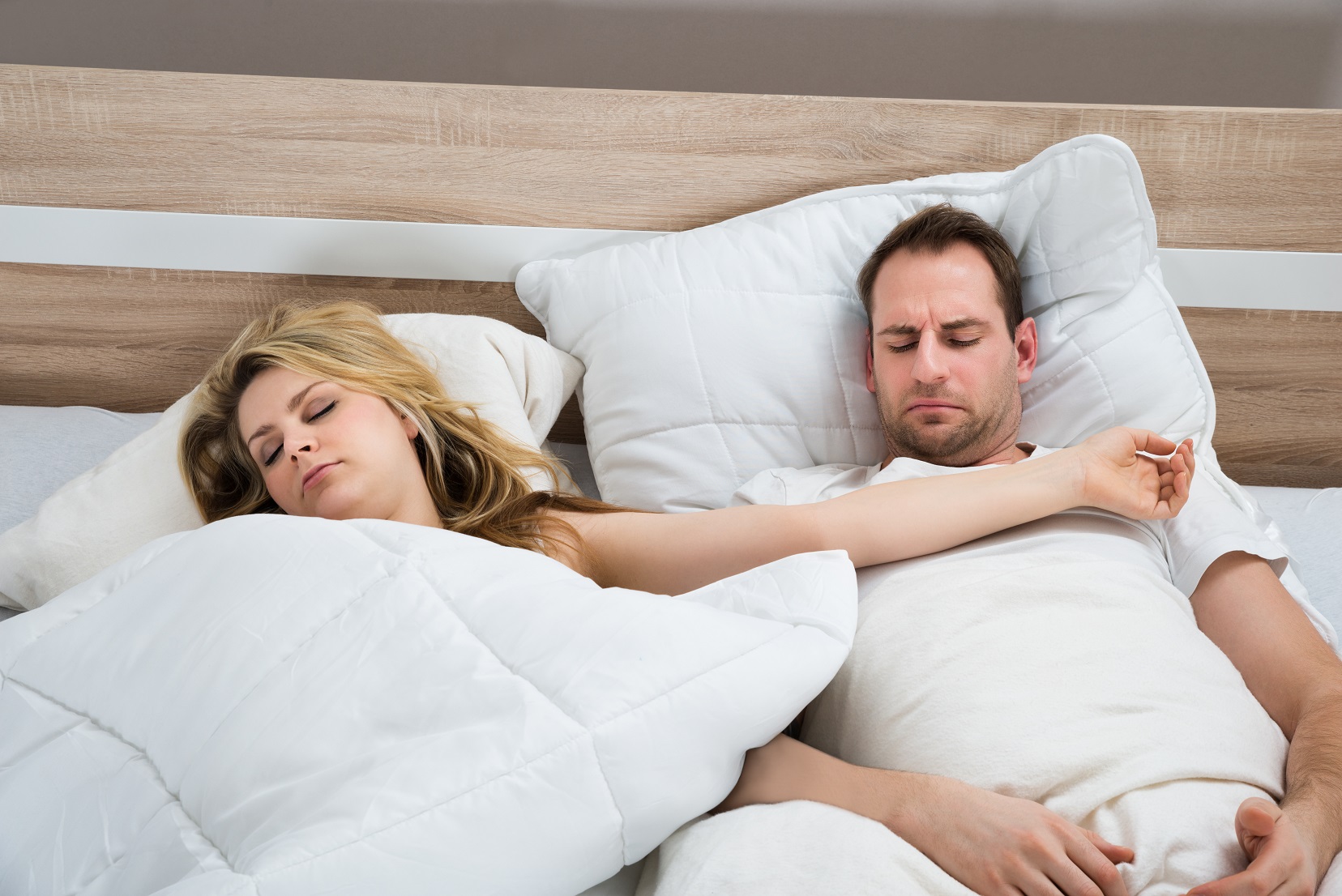 Спящий муж на скрытую. Супружеская кровать. Два человека лежат на кровати.